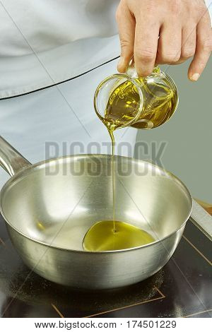 Chef pours oil into the pan for cooking