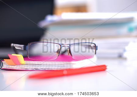 Group of multicolored office folders and glasses.