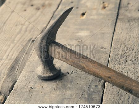 Old used vintage hammer on a wooden workbench