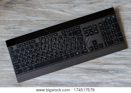 Computer black keyboard isolated on wood background.
