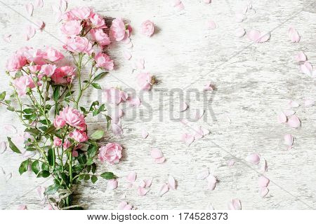 pink rose flowers bouquet mockup on white rustic wooden background for creative work design. top view. vintage toning