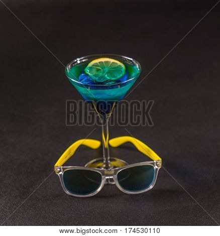 colored drink a combination of blue and green lemon martini glass yellow sunglasses party set