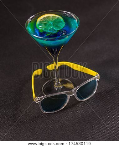 colored drink a combination of blue and green lemon martini glass yellow sunglasses party set
