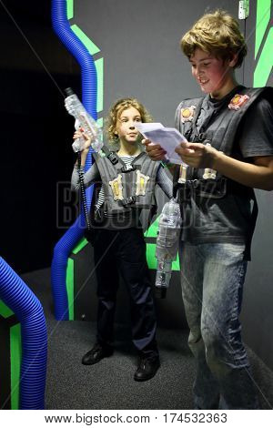 MOSCOW - DEC 13, 2014: Brother and sister in special vests with laser guns in laser tag at the shopping center Capitol Vernadsky