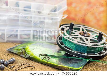 fishin acsessories and old reel on the wooden table