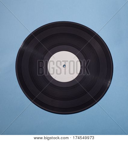 black vinyl disс isolated on blue background with blank white area in center