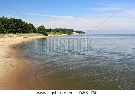 Sand beach of the Curonian lagoon near Morskoe (Pillkoppen) village in the Curonian Spit National Park. Russia.