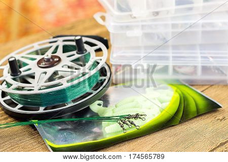fishin acsessories and old reel on the wooden table
