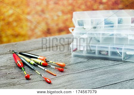 Fishing floats with acsessories on the wooden table at autumn background
