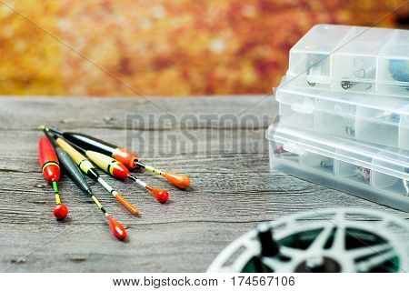 Fishing floats with acsessories on the wooden table at autumn background
