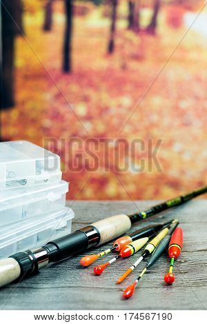 fishing rod with acsessories on the grey wooden table at autumn background