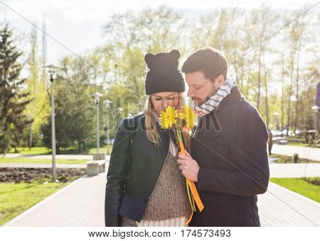 Portrait of romantic man giving flowers to woman.