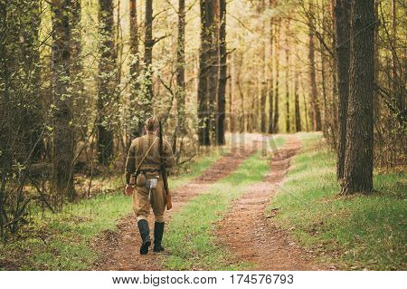 Re-enactor Dressed As Soviet Russian Red Army Infantry Soldier Of World War II Marching Along Forest Road At Spring Season.
