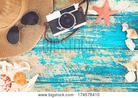 Summer background - The concept of leisure travel in the summer on a tropical beach seaside. retro camera with starfish shells coral on wood table background. vintage color tone styles.