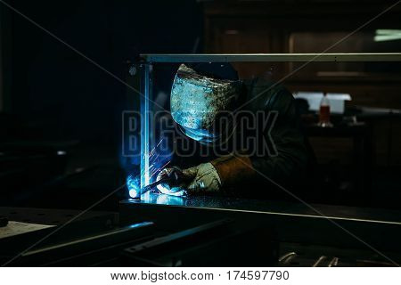 sparks while welder uses torch to welding in gloves