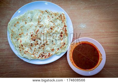 Roti canai or roti Prata with curry sauce.This is the famous authentic recipe used by the Indians in Malaysia.