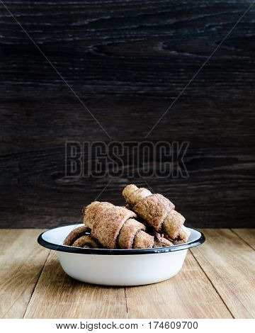 Croissants in a white plate on wooden table. Selective focus. Copy space