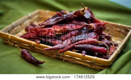 Dried red peppers are lying in a heap glitering with different shades of red