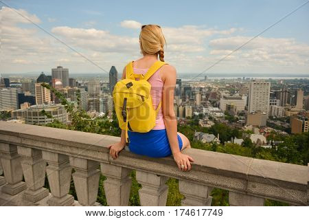 Blonde woman looking at Montreal downtown skyline cityscape. Canada.