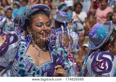 ARICA, CHILE - FEBRUARY 10, 2017: Female members of a Caporales dance group in ornate costumes performing at the annual Carnaval Andino con la Fuerza del Sol in Arica, Chile.