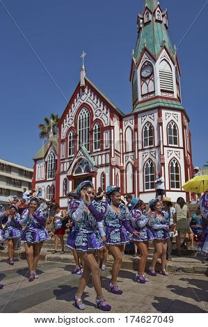ARICA, CHILE - FEBRUARY 10, 2017: Female members of a Caporales dance group in ornate costumes performing at the annual Carnaval Andino con la Fuerza del Sol in Arica, Chile.