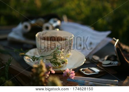 a cup of tea in the sunset light and pearl opera glasses