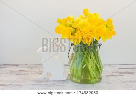 Easter eggs hunt - white rabbit and daffodils bouquet