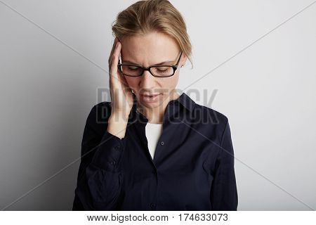 Stressed Woman With Headache In Corporate Office. White Background.