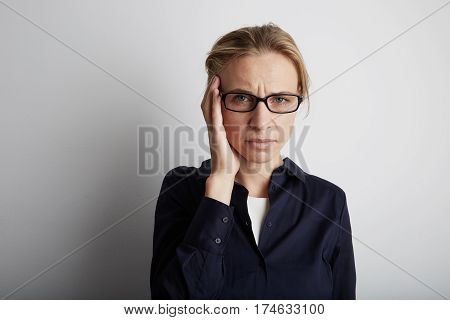 Stressed Young Woman With Headache In Corporate Office. White Background.