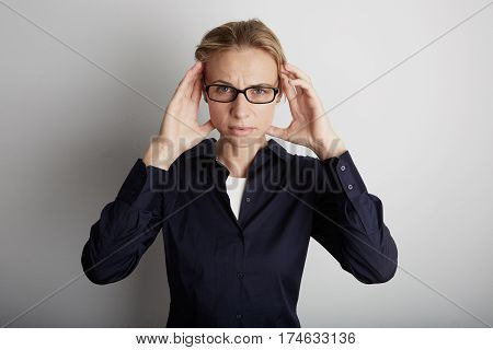 Stressed Young Woman With Headache In Corporate Office. White Background.