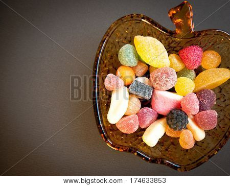 colored candies inside an apple-shaped glass bowl