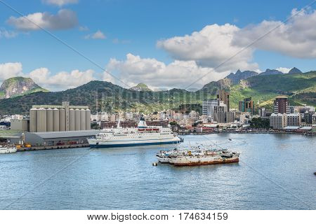 Port Louis Mauritius - December 12 2015: Port Louis cityscape Mauritius. Ships in the harbor in the foreground. The city is the country's economic cultural political centre and most populous city.