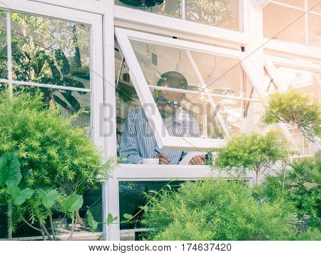 Young Business Man Sitting In Bar Near Window While Holding Notebook With Pencil To Skech His Idea