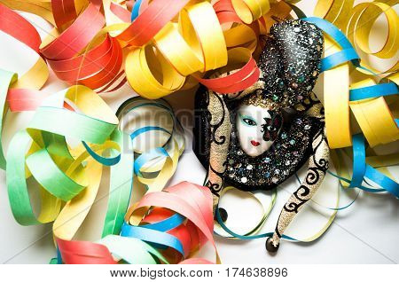 carnival mask in the middle of colored streamers