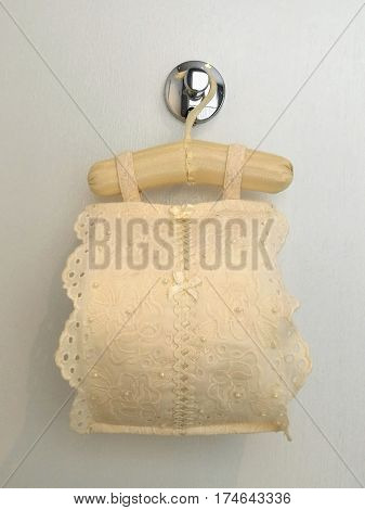 Roll tissue cloth lace fabric cover with toilet paper roll for sanitary inside hanging on white background bathroom closed up