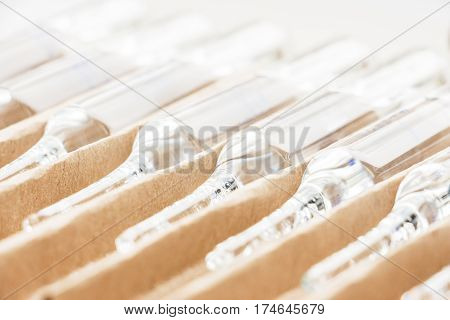Row of transparent medical ampules in package. Close up