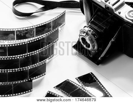 black and white photo of an old analogue camera displayed with negatives