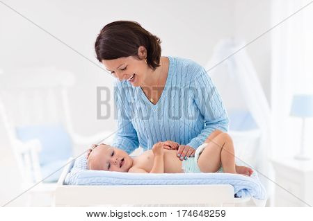 Mother Changing Diaper To Baby Boy