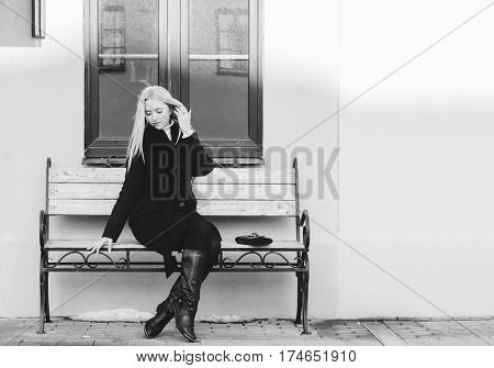 Young pretty blonde girl on the urban bench