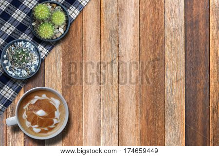 Hot cappuccino and cactus on wooden top view background
