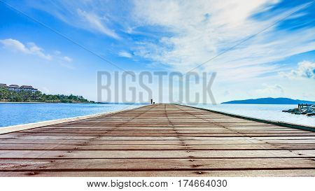 Wooden plank pier with seascape and bright blue sky for relax time at Khao Leam Ya National Park Rayong Province Thailand