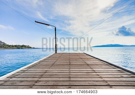 Wooden plank pier with seascape and bright blue sky for relax time at Khao Leam Ya National Park Rayong Province Thailand