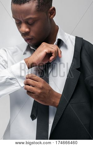 Fashion clothes, brand jackets, expensive men suits. African american guy in office dress code on grey background.