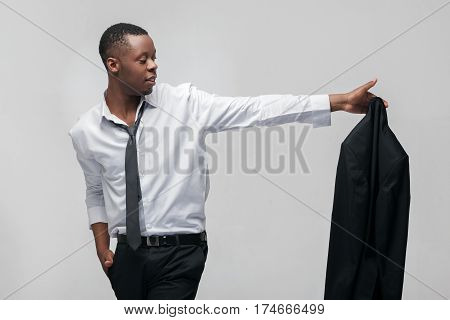 Businessman leaving office job. Going to the new level, next stage. African american guy on grey background.