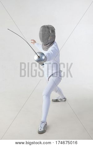 Female fencer wearing white fencing costume isolated on white background