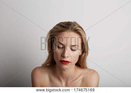 Portrait of beautiful young woman with blonde hair wearing red lipstick.