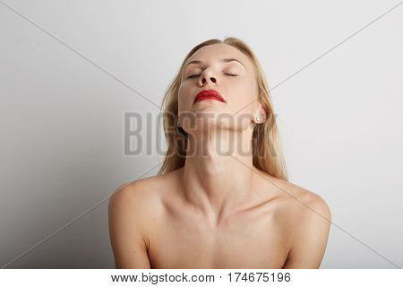 Portrait of beautiful young woman with blonde hair wearing red lipstick.