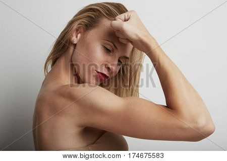 Portrait of beautiful young woman with blonde hair wearing nude bra.