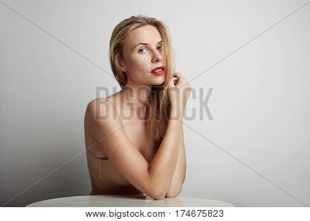 Portrait of beautiful young woman with blonde hair wearing nude bra.