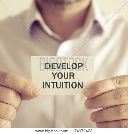 Businessman Holding Develop Your Intuition Message Card